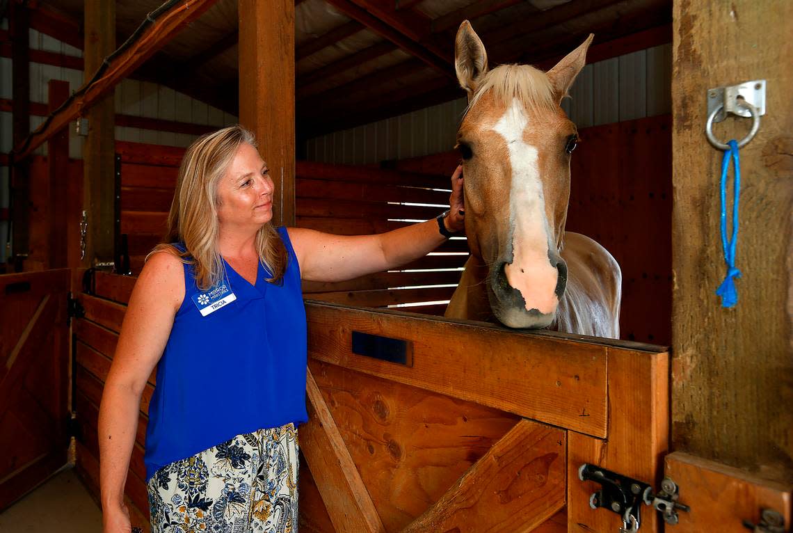Tricia MacFarlan, Mirror Ministries executive director, rubs Harmony, an equine therapy horse, at the newly remodeled Esther’s Home in rural Franklin County.