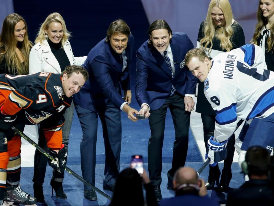 Former Winnipeg Jets Teppo Numminen, right, and Teemu Selanne drop the puck during a ceremony where they were inducted into the Winnipeg Jets Hall of Fame prior to the NHL game between the Jets and Anaheim Ducks at Canada Life Centre on Thursday evening. (John Woods/the Canadian Press - image credit)