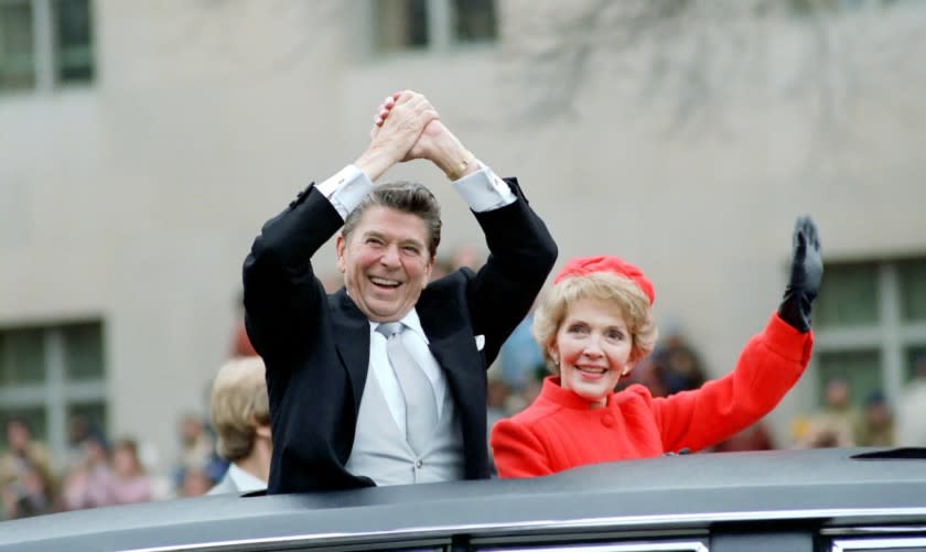 President Reagan and Nancy Reagan wave from the limousine during the inaugural parade in Washington on Jan. 20, 1981. 