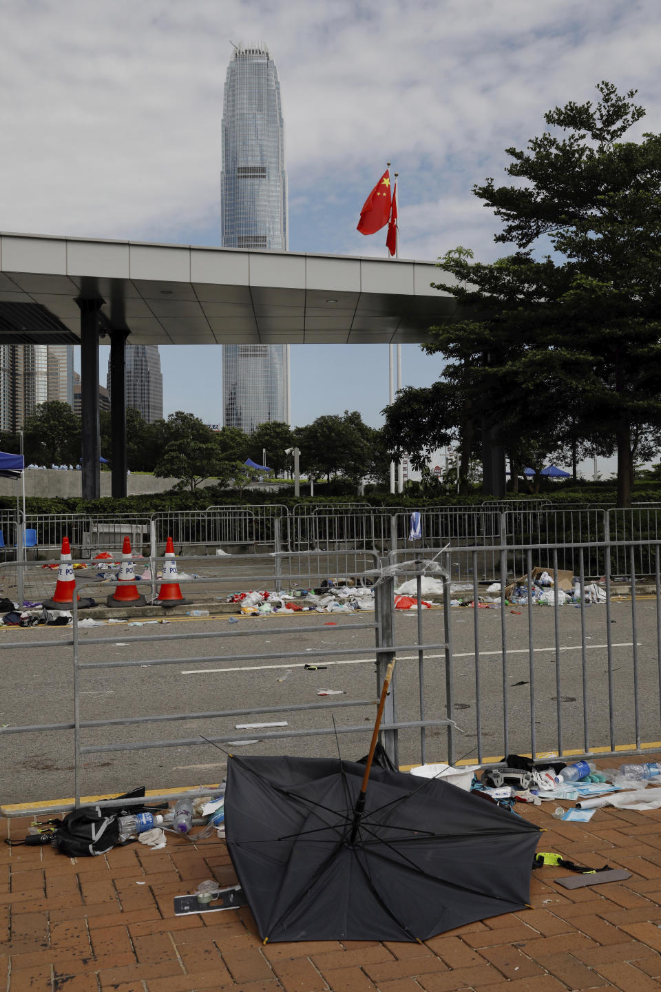 A broken umbrella left in the aftermath of Wednesday's violent protest against proposed amendments to an extradition law is seen near the Chinese flag in Hong Kong on Friday, June 14, 2019. Calm appeared to have returned to Hong Kong after days of protests by students and human rights activists opposed to a bill that would allow suspects to be tried in mainland Chinese courts. (AP Photo/Vincent Yu)