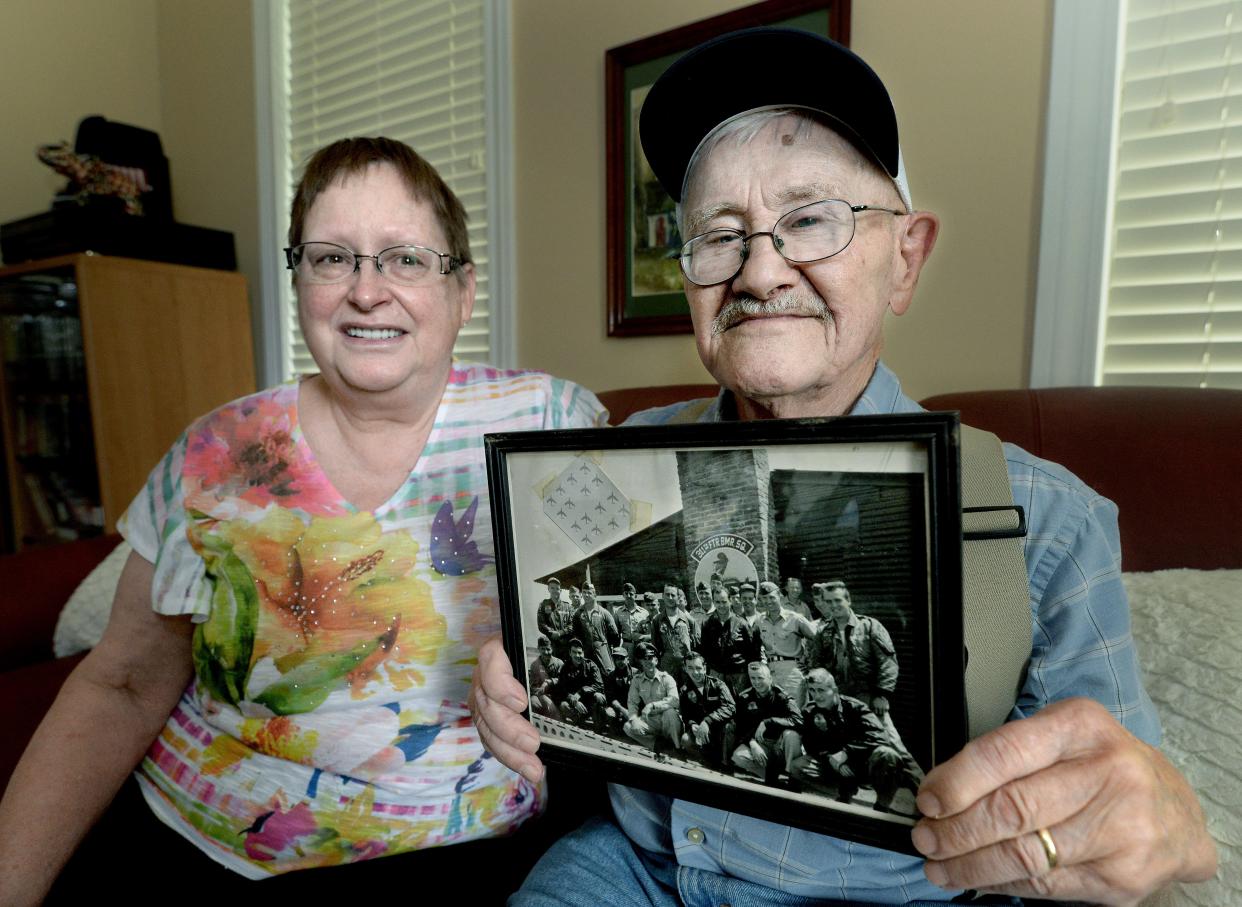 Richard "Mick" Bray, right, holds up a photo of himself and the 311th Tactical Fighter Squadron from his time in service in Korea. Bray was a pilot in the U.S. Air Force and was stationed at Osan Air Base from 1958 to 1959. Now 88, Bray will be part of Tuesday's Land of Lincoln Honor Flight along with his guardian, Vi Lanum, left, a long-time family friend. It is the first Honor Flight to operate from Springfield since October 2019 because of the COVID-19 pandemic.