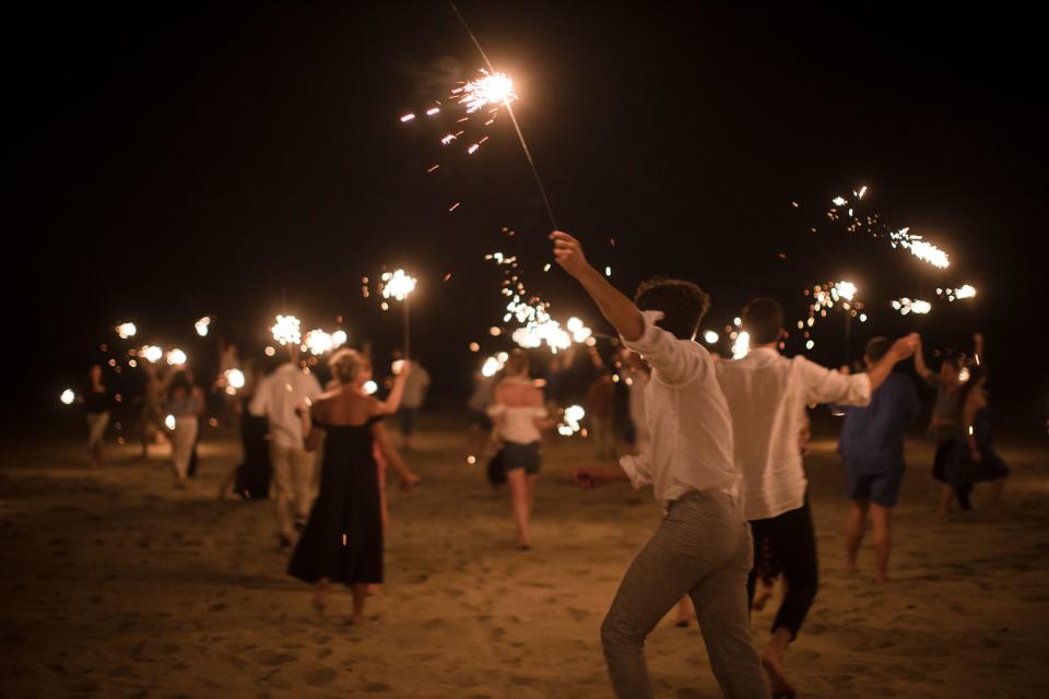 All of our guests running with sparklers on the beach outside Hotel Escondido.