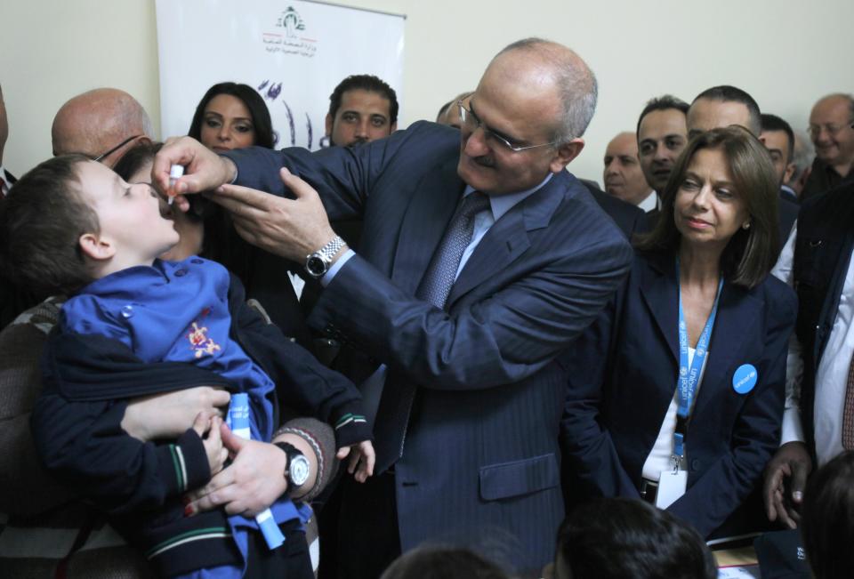 Lebanon's Caretaker Health Minister Khalil administers a polio vaccination to a boy at a hospital in the Bekaa Valley