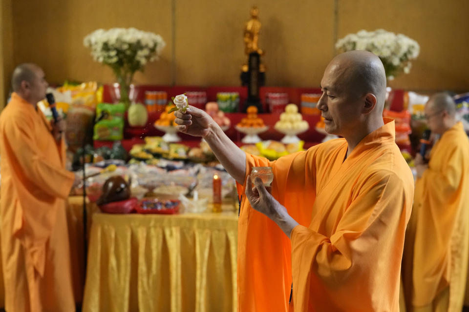 A monk holds a rose during ceremonies as part of their observance of the coming Chinese New Year at the Seng Guan temple at the edge of Manila's Chinatown, Philippines said to be the oldest in the world, on Monday, Feb. 5, 2024. Crowds are flocking to Manila's Chinatown to usher in the Year of the Wood Dragon and experience lively traditional dances on lantern-lit streets with food, lucky charms and prayers for good fortune. (AP Photo/Aaron Favila)