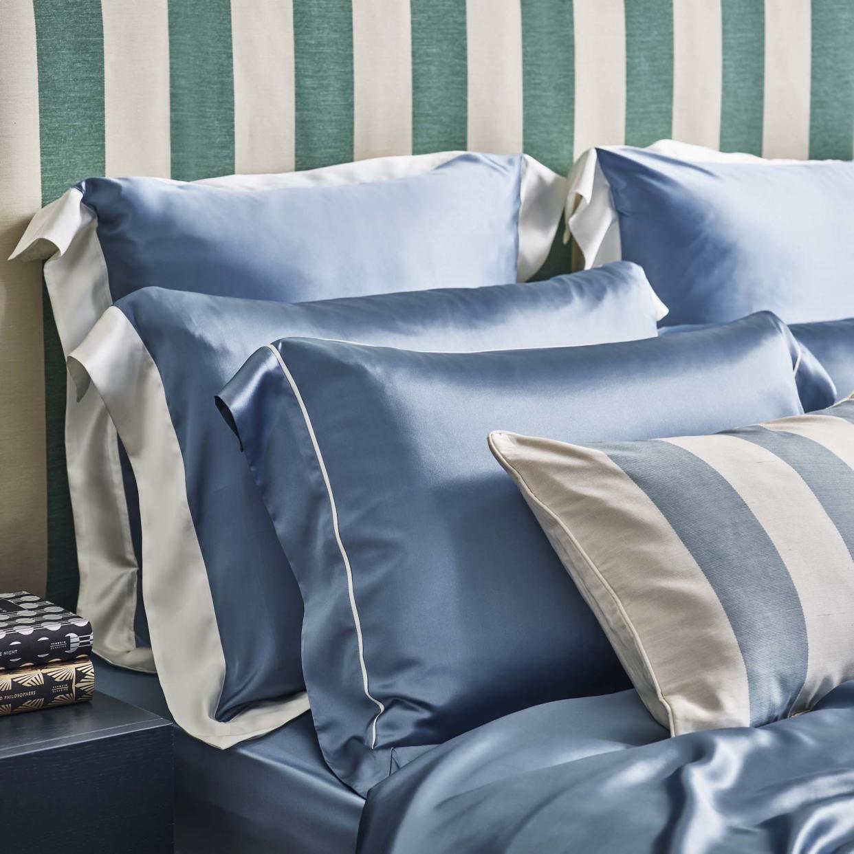  Silk sheets on bed with striped headboard. 