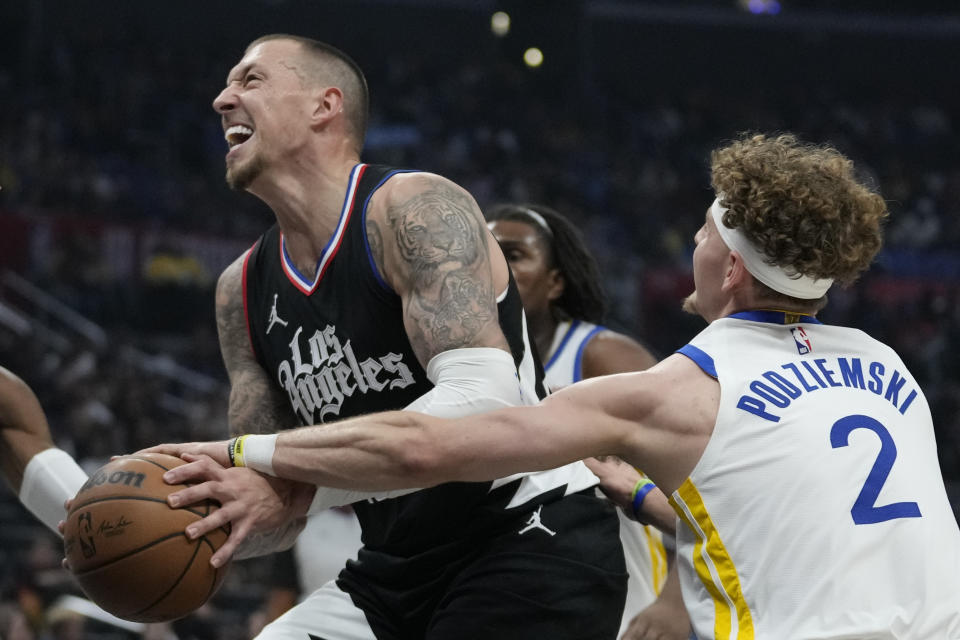 Golden State Warriors guard Brandin Podziemski (2) fouls Los Angeles Clippers center Daniel Theis during the first half of an NBA basketball game in Los Angeles, Saturday, Dec. 2, 2023. (AP Photo/Ashley Landis)