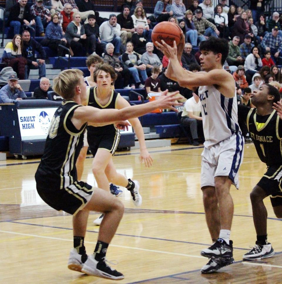 Sault forward Nathan Koepp gets surrounded by three St. Ignace players during the third quarter of Thursday nights Straits Area Conference showdown.  Koepp finished with 16 points as the Blue Devils notched the win.