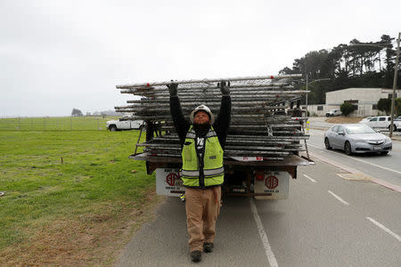 A worker unloads a chainlink fence at Crissy Field in anticipation of Saturday's Patriot Prayer rally and counter demonstration in San Francisco, California, U.S. August 25, 2017. REUTERS/Stephen Lam