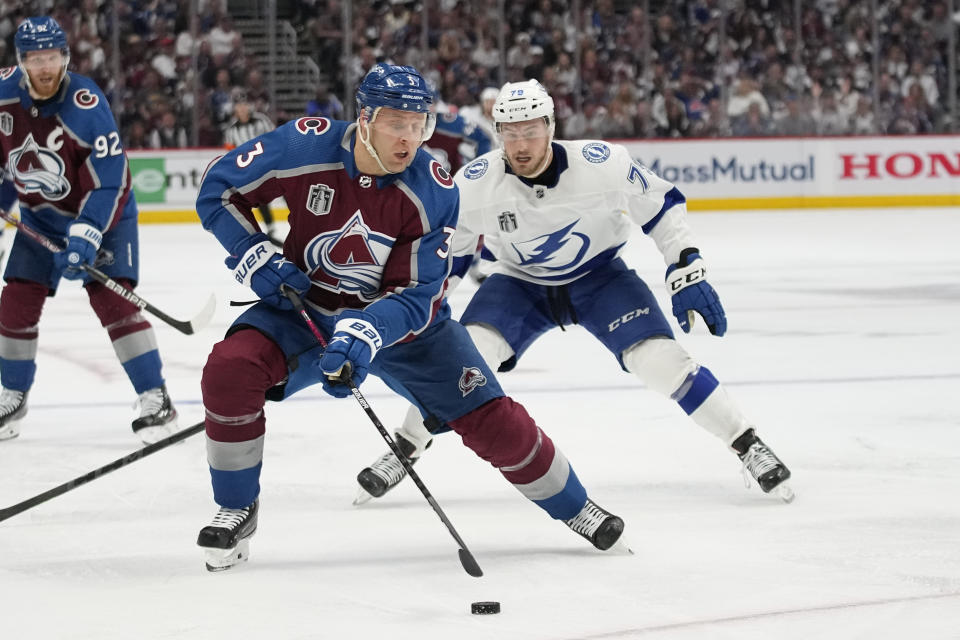 Colorado Avalanche defenseman Jack Johnson (3) controls the puck as Tampa Bay Lightning center Ross Colton (79) defends during the third period in Game 2 of the NHL hockey Stanley Cup Final, Saturday, June 18, 2022, in Denver. (AP Photo/John Locher)