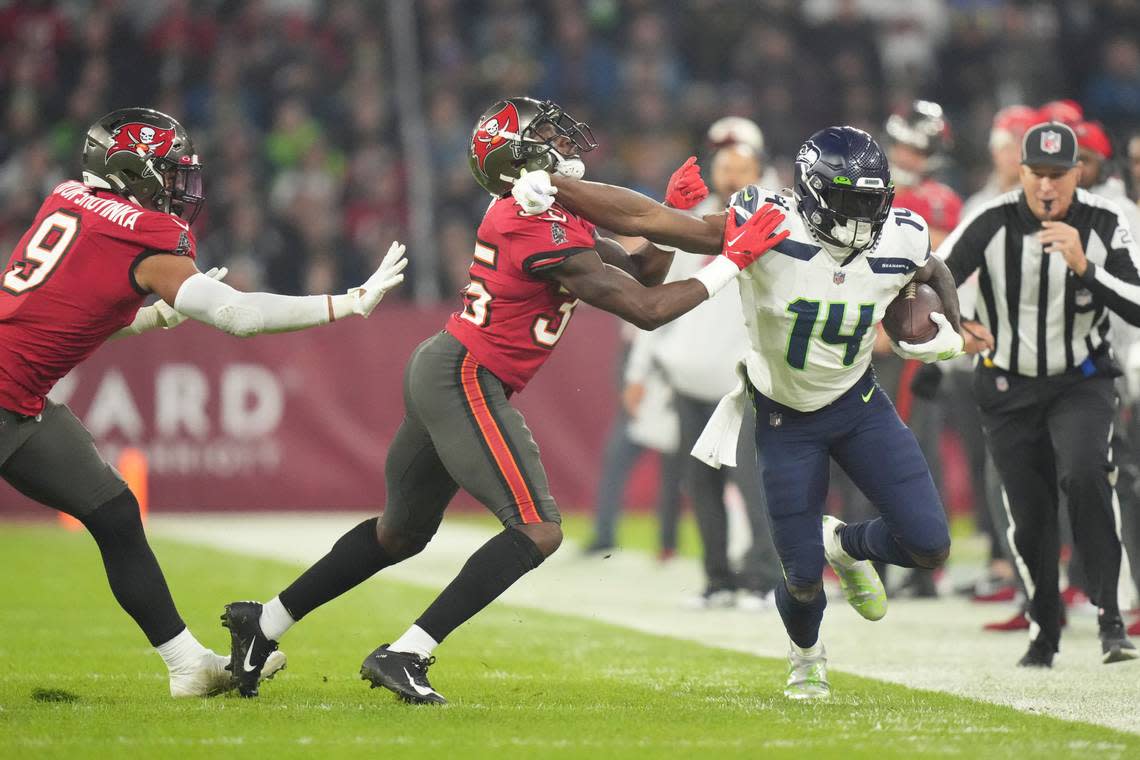 Seattle Seahawks’ DK Metcalf (14) is tackled by Tampa Bay Buccaneers’ Jamel Dean (35) during the second half of an NFL football game, Sunday, Nov. 13, 2022, in Munich, Germany. (AP Photo/Matthias Schrader)