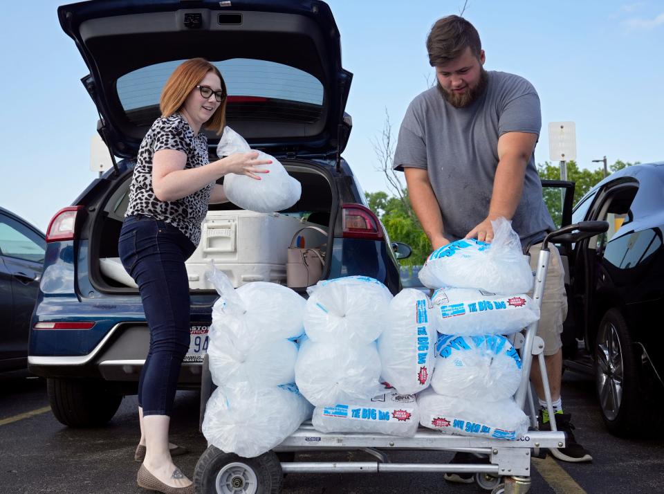 Columbus, Ohio, United States; Amanda Nyeste, a sales assistant for Cameron Mitchell Premier Events, and Barrett Kinnaman of Whitehall unload bags of ice to donate after the Franklin County Dog Shelter & Adoption Center lost power and had no air conditioning on Tuesday, June 14, 2022. Cameron Mitchell donated Nyeste's load of ice. Kinnaman has previously adopted a dog from the shelter. Mandatory Credit: Barbara J. Perenic/Columbus Dispatch