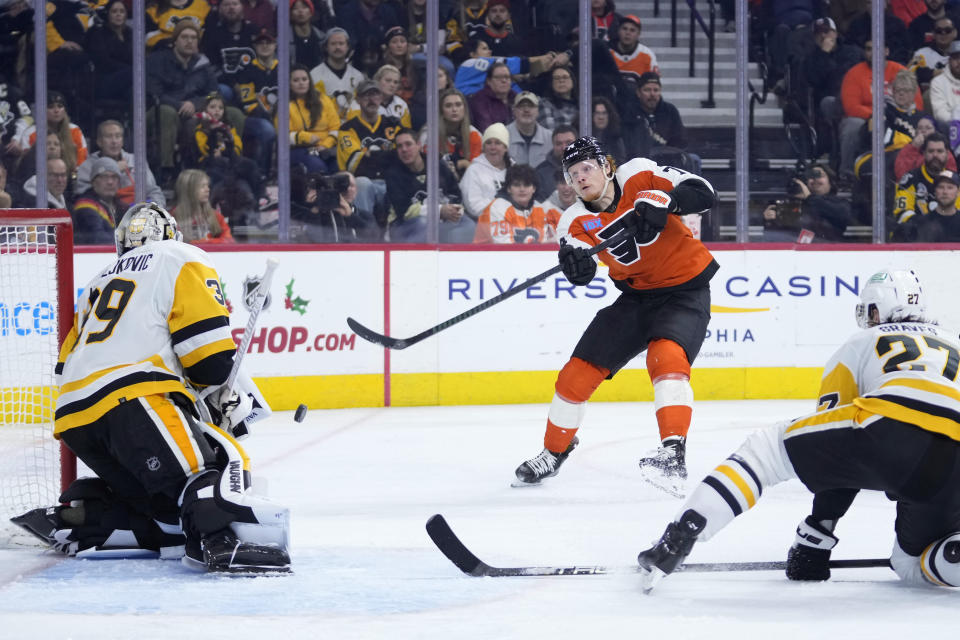 Philadelphia Flyers' Owen Tippett, center, tries to get a shot past Pittsburgh Penguins' Alex Nedeljkovic, left, and Ryan Graves during the second period of an NHL hockey game, Monday, Dec. 4, 2023, in Philadelphia. (AP Photo/Matt Slocum)