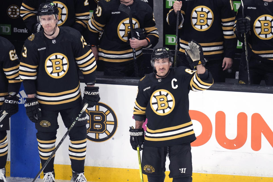 Boston Bruins left wing Brad Marchand waves while honored while playing in his 1,000th NHL hockey game, this one againstt the Tampa Bay Lightning, Tuesday, Feb. 13, 2024, in Boston. Marchand, drafter in 2006, has spent his entire NHL career with Boston. (AP Photo/Charles Krupa)