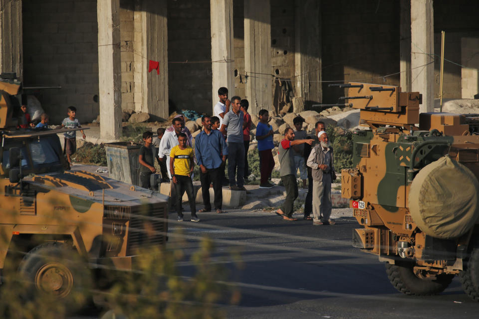 Shortly after the Turkish operation inside Syria had started, local residents cheer and applaud as a convoy of Turkish forces vehicles is driven through the town of Akcakale, Sanliurfa province, southeastern Turkey, at the border between Turkey and Syria, Wednesday, Oct. 9, 2019. Turkey launched a military operation Wednesday against Kurdish fighters in northeastern Syria after U.S. forces pulled back from the area, with a series of airstrikes hitting a town on Syria's northern border.(AP Photo/Lefteris Pitarakis)