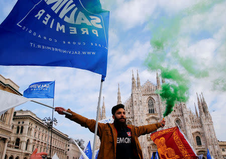 An Italian Northern League supporter holds a flare during a political rally led by leader Matteo Salvini in Milan, Italy February 24, 2018. REUTERS/Tony Gentile