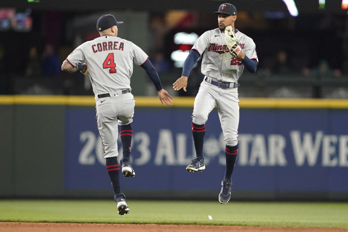 Minnesota Twins' Carlos Correa (4) and Byron Buxton celebrate after the team's 5-0 win in a baseball game against the Seattle Mariners, Wednesday, June 15, 2022, in Seattle. (AP Photo/Ted S. Warren)