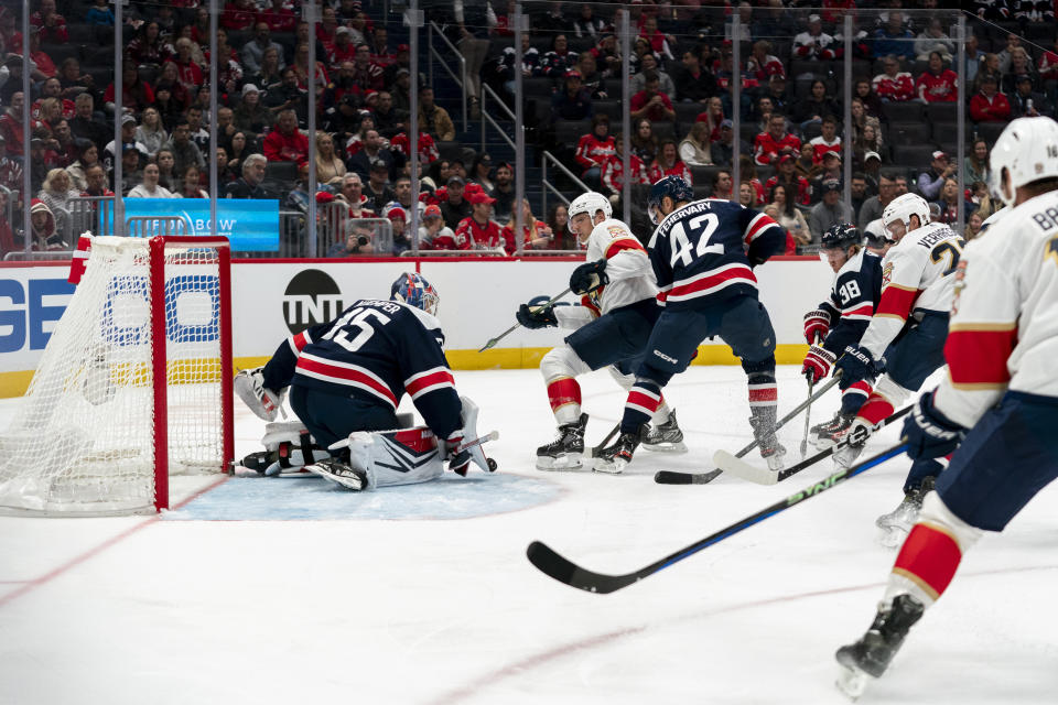 Washington Capitals goaltender Darcy Kuemper, left, makes a save during the second period of an NHL hockey game against the Florida Panthers, Wednesday, Nov. 8, 2023, in Washington. (AP Photo/Stephanie Scarbrough)