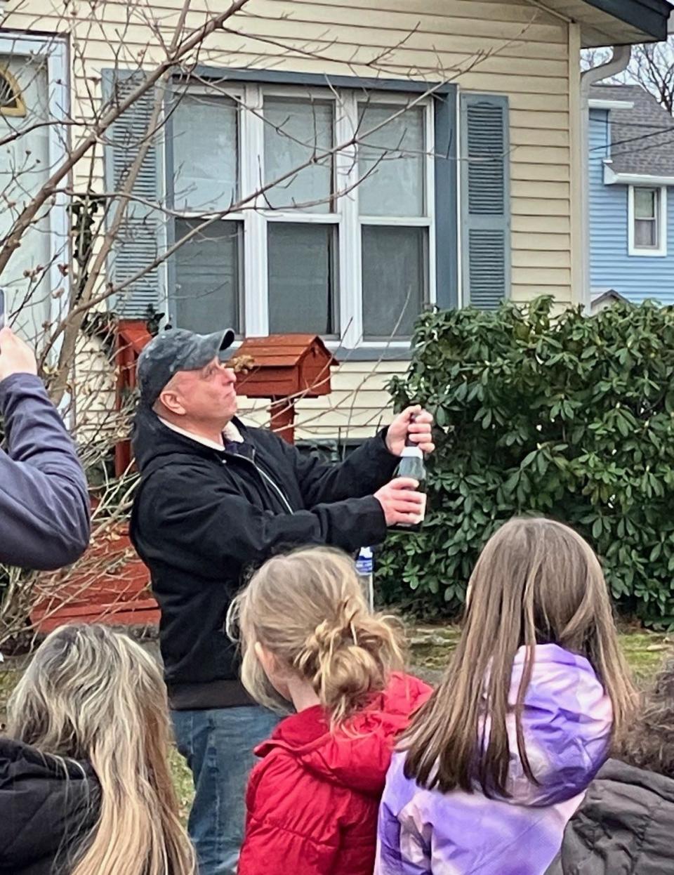 Edison resident Ron Loeffler pops a bottle to celebrate that a huge warehouse will not be built in his neighborhood after the township acquired the property.