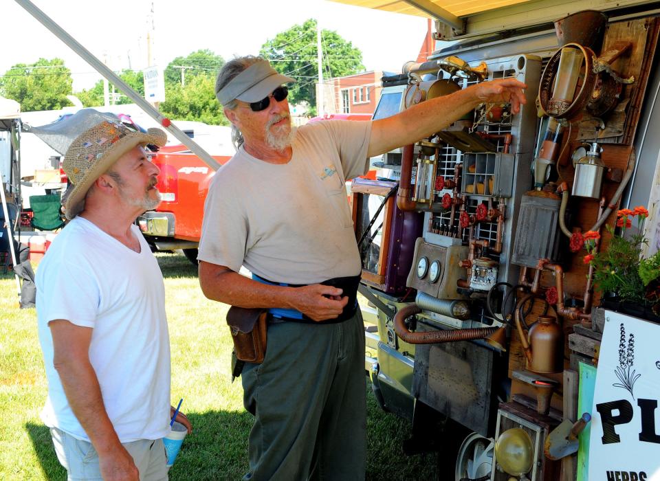 Paul Carmichael, right, explains scientific instruments to Anthony Floriani on Saturday, June 25, 2022, in the "All Things Science" booth at the Alliance Farmers Market.