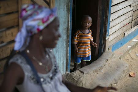 A Sierra Leonean boy looks out of a doorway in Freetown, Sierra Leone, December 16, 2014. REUTERS/Baz Ratner