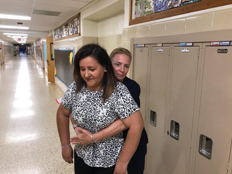 School nurse Sue Scalgione demonstrates the Heimlich maneuver on Freehold Borough teacher Veronica Fiori at Park Avenue Elementary School in Freehold Borough