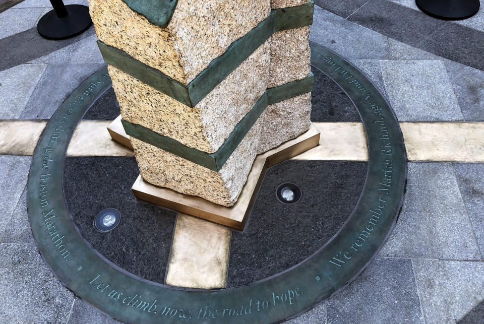 Inscriptions ring the base of two of the stone pillars completed Monday, Aug. 19, 2019, in Boston to memorialize the Boston Marathon bombing victims at the sites where they were killed. Martin Richard, Krystle Campbell and Lingzi Lu were killed when bombs were detonated at two locations near the finish line on April 15, 2013. (AP Photo/Philip Marcelo)