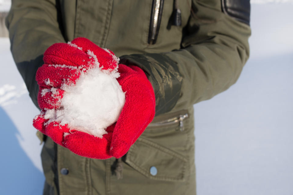 A snowball in red gloved hands