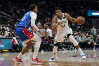 Milwaukee Bucks forward Giannis Antetokounmpo, right, of Greece, drives against Washington Wizards center Daniel Gafford in the first half of an NBA basketball game, Sunday, Nov. 7, 2021, in Washington. (AP Photo/Patrick Semansky)