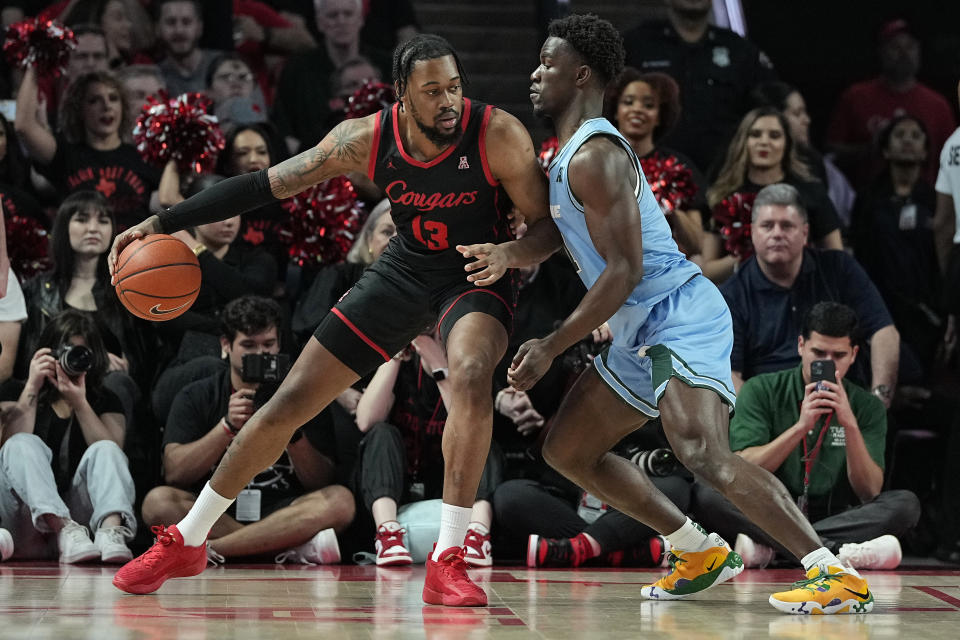 Houston forward J'Wan Roberts is defended by Tulane guard Sion James during the first half of an NCAA college basketball game Wednesday, Feb. 22, 2023, in Houston. (AP Photo/Kevin M. Cox)