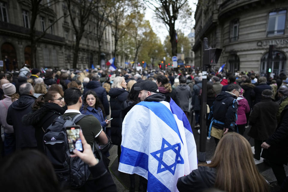 A demonstrator wearing an Israeli flag joins thousands other people for a march against antisemitism in Paris, France, Sunday, Nov. 12, 2023. French authorities have registered more than 1,000 acts against Jews around the country in a month since the conflict in the Middle East began. (AP Photo/Christophe Ena)