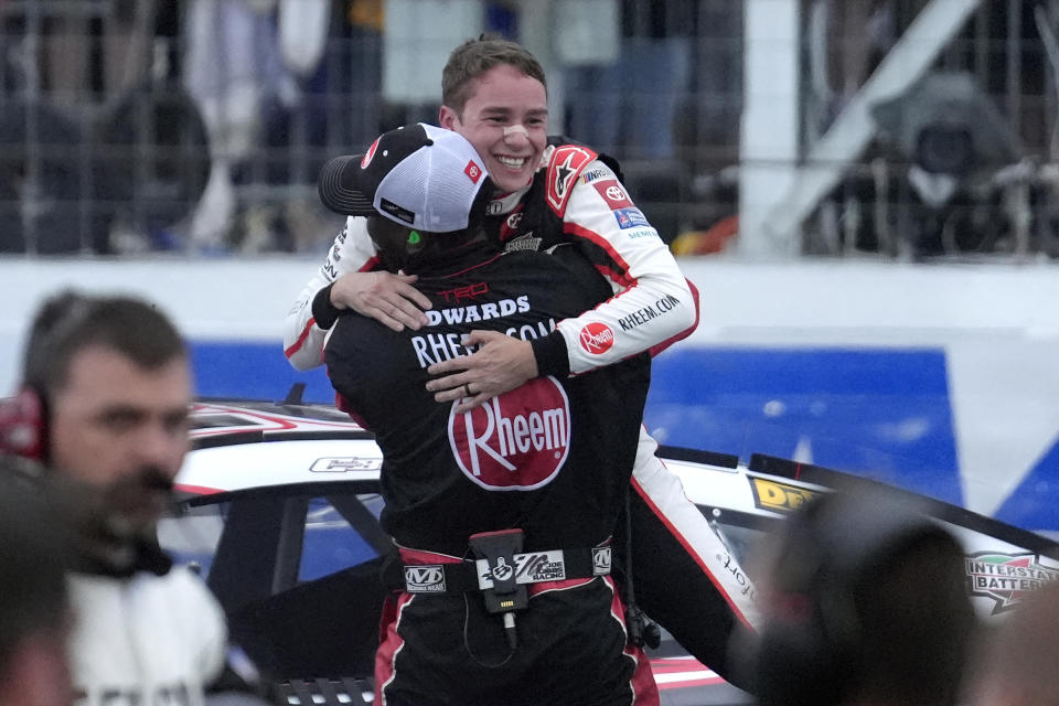 Christopher Bell, top, celebrates with a crew members as he steps out of his car after winning the NASCAR Cup Series race at New Hampshire Motor Speedway, Sunday, June 23, 2024, in Loudon, N.H. (AP Photo/Steven Senne)