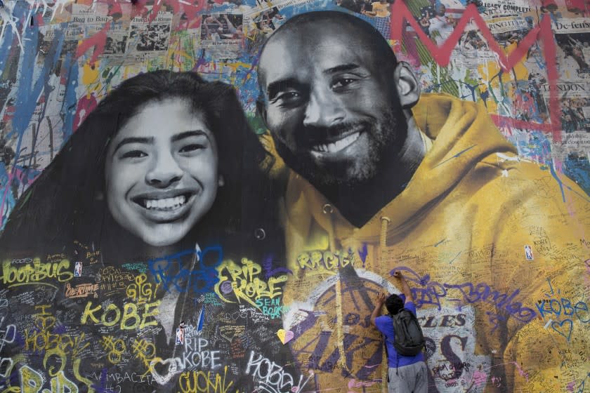 Ernest Wilson of Dallas, Texas writes a message on Thierry Guetta's mural in the 1200 block of S. La Brea Ave. on Feb. 27.