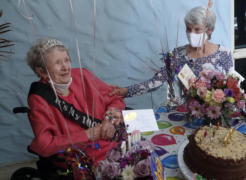 Lynn Foley, right, of Deerfield Beach reaches out to her mother, Vernice Huff, as they celebrate her 100th birthday at John Knox Village, Thursday, Sept. 3, 2020, in Pompano Beach, Fla. The visit became possible with the lifting of nursing home visitation restrictions during the coronavirus pandemic. (Joe Cavaretta/South Florida Sun-Sentinel via AP)