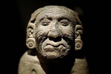 A stone kneeling figure of the goddess of fertility and land Coatlicue, one of pre-Columbian artefacts, is presented to the press at Drouot auction house in Paris