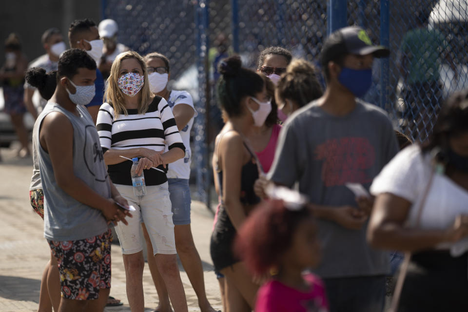 People wait in line for a COVID-19 test amid the new coronavirus pandemic at a plaza in Duque de Caxias, Brazil, Monday, June 8, 2020. Brazil's government has stopped publishing a running total of coronavirus deaths and infections in an extraordinary move that critics call an attempt to hide the true toll of the disease in Latin America's largest nation. (AP Photo/Leo Correa)