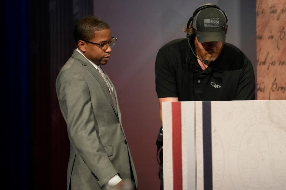 Healthcare advocate Carlton Boyd, left, gets fitted with a microphone ahead of a Democratic gubernatorial debate on Friday, June 10, 2022, in Columbia, S.C. (AP Photo/Meg Kinnard)