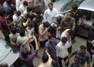 FILE - In this May 11, 2019, file photo, detained Chinese nationals whose alleged involvement in a trafficking gang to lure Pakistani women into fake marriages, try to shield their faces while they are escorted by Pakistan's Federal Investigation Agency officers to court in Lahore, Pakistan. Pakistan's Federal Investigation Agency arrested the Chinese nationals in raids in the Punjab province in connection with trafficking. The raids followed an undercover operation that included attending an arranged marriage, local media reported. (AP Photo/K.M. Chaudary, File)