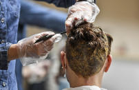 Hairdresser Ute Augustin colors hair of a customer at a barber shop in Gelsenkirchen, Germany, Monday, March 1, 2021. Hairdressers across Germany have reopened for business this morning after a more than 2-month closure, another cautious step as the country balances a desire to loosen restrictions with concern about the impact of more contagious coronavirus variants. (AP Photo/Martin Meissner)