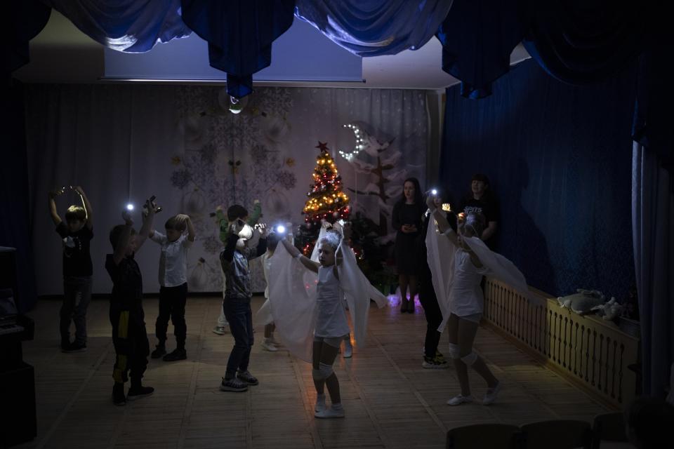 Niños de la escuela Barentsburg bailan vestidos de blanco para celebrar la Navidad ortodoxa en Barentsburg, Noruega, el sábado 7 de enero de 2023. (AP Foto/Daniel Cole)