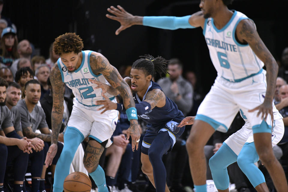 Charlotte Hornets guard Kelly Oubre Jr., left, and Memphis Grizzlies guard Ja Morant struggle for control of the ball during the first half of an NBA basketball game Friday, Nov. 4, 2022, in Memphis, Tenn. (AP Photo/Brandon Dill)