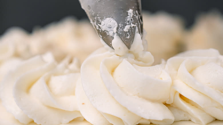 Piping frosting onto a cake