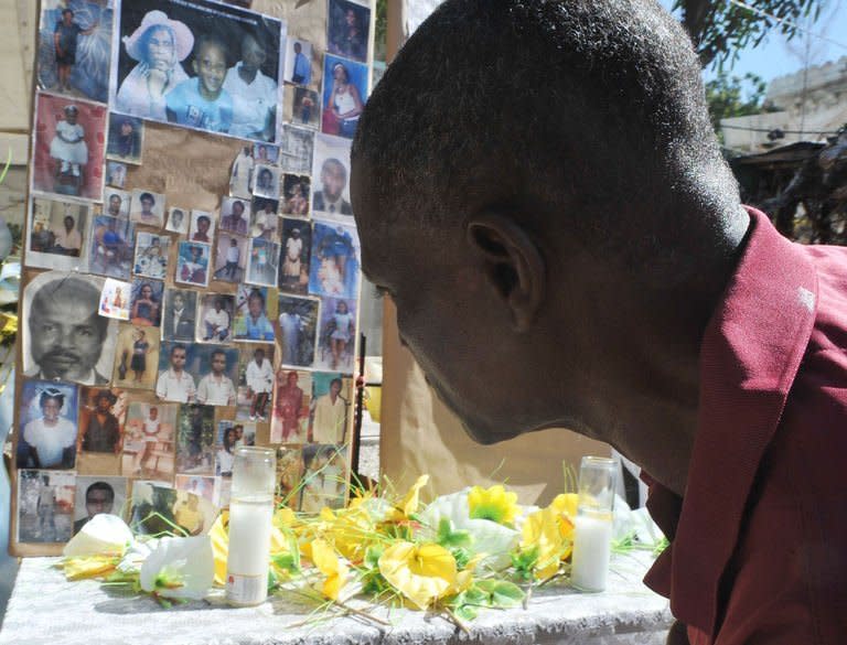 A man pays his respects at a makeshift memorial for victims of the January 12, 2010 Haiti earthquake near the destroyed Cathedral of Port-au-Prince on January 12, 2013