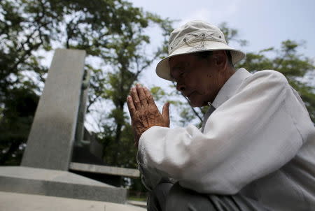 Yoshiteru Kohata, a 86-year-old Nagasaki atomic bombing survivor and retired school teacher, who returned to his home region of Fukushima after World War Two, prays at the Haranomachi Airfield Monument in Minamisoma, Fukushima Prefecture, Japan, July 31, 2015. REUTERS/Toru Hanai