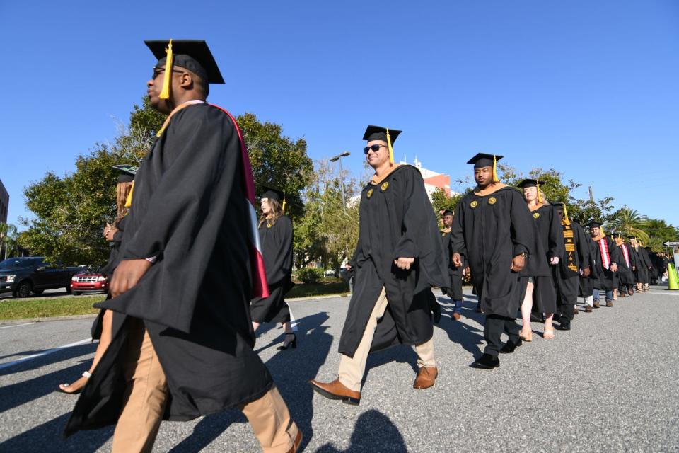 Florida Institute of Technology students march toward graduation services Saturday in Melbourne.