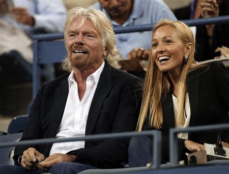 Virgin Group founder Richard Branson of Britain sits with Jelena Ristic, girlfriend of Serbian tennis player Novak Djokovic, at the U.S. Open tennis championships in New York September 5, 2013. REUTERS/Mike Segar