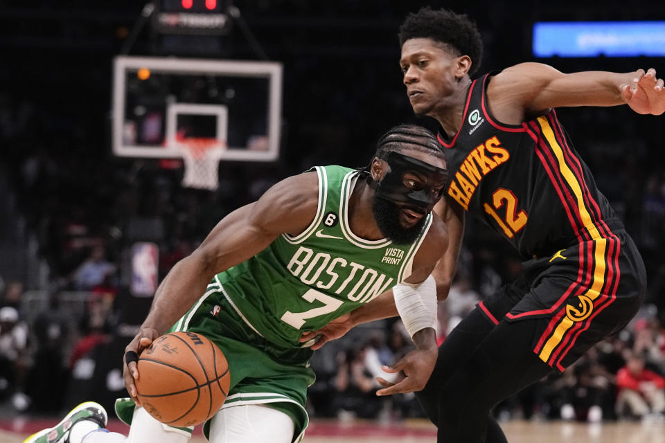 Boston Celtics guard Jaylen Brown (7) drives the ball to the basket against Atlanta Hawks forward De'Andre Hunter (12) during the second half of Game 3 of a first-round NBA basketball playoff series, Friday, April 21, 2023, in Atlanta. (AP Photo/Brynn Anderson)