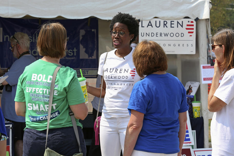 In this Aug. 12, 2018, photo, rookie Democratic candidate Lauren Underwood talks with supporters in Lindenhurst, Ill. If elected to the U.S. House, Underwood would be the first woman and first minority to represent the predominantly white district once represented by GOP House Speaker Dennis Hastert. (AP Photo/Teresa Crawford)