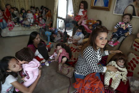 Devotees play with "child angel" dolls at a house in Nonthaburi, Thailand, January 26, 2016. REUTERS/Athit Perawongmetha