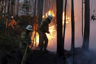 <p>Firefighters of the Portuguese National Republican Guard work to stop a forest fire from reaching the village of Avelar, central Portugal, at sunrise Sunday, June 18 2017. (Armando Franca/AP), </p>