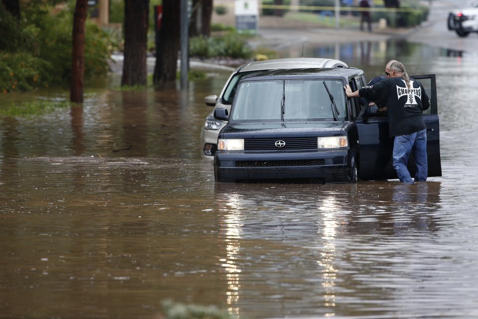 A driver waits to get towed out of flooded street during a flash flood as a result of heavy rains from tropical storm Rosa Tuesday, Oct. 2, 2018, in Phoenix. (AP Photo/Ross D. Franklin)